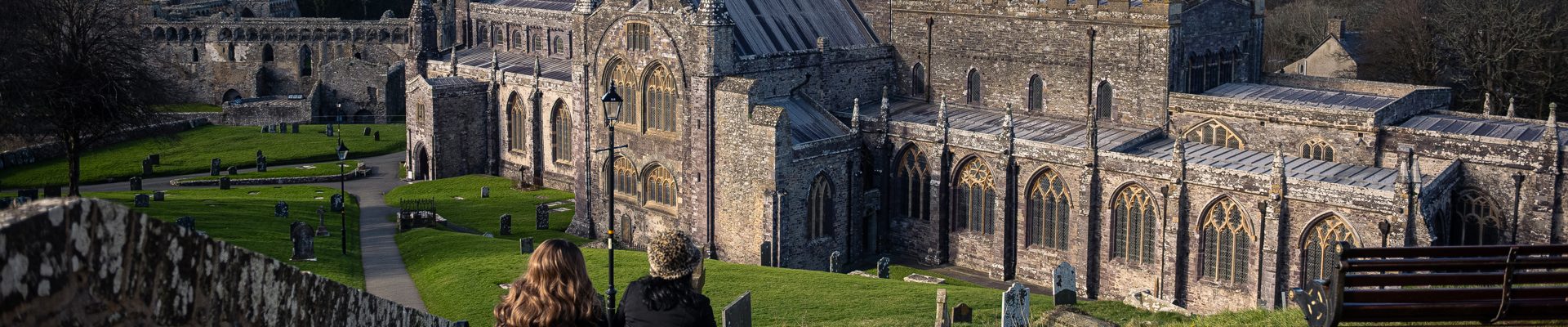 Two people sit on a bench looking at a cathedral